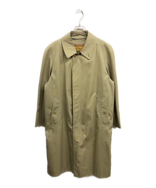 Front view of a women's khaki trench coat hanging on a hanger against a white background.