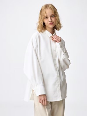 Model wearing a white women's dolman-sleeve polyester shirt.
