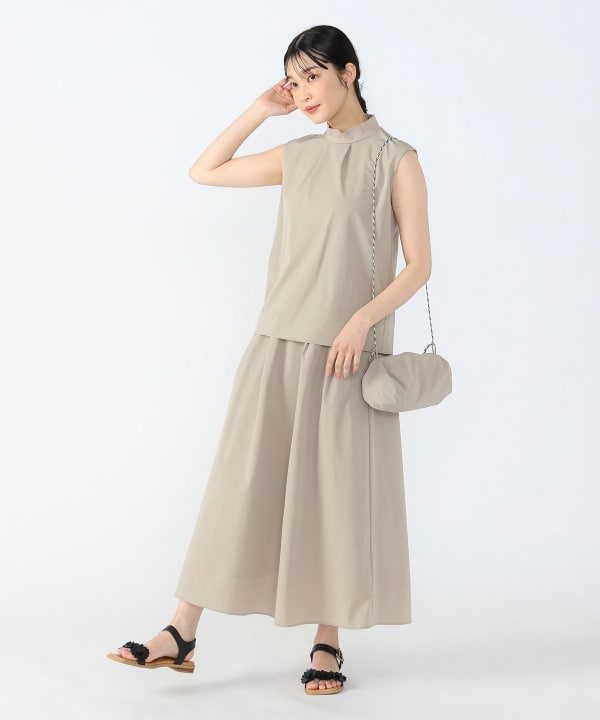 A model wearing the sleeveless setup dress with a matching chain-strap shoulder bag against a white background.