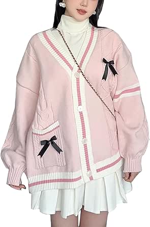 Pink open-front V-neck knit cardigan with white trim, front pockets and black bow accents shown worn by a model.