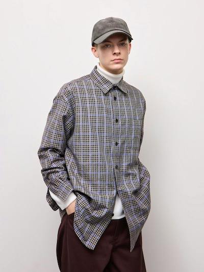 Women's checked flannel shirt (polyester) worn by a model over a white turtleneck and a grey cap.