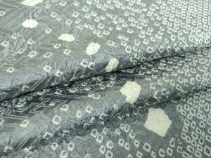 Close-up photo of silk kimono fabric showing a komon shibori pattern.