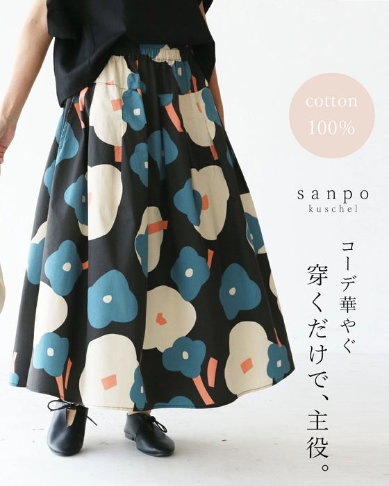 Model wearing a long cotton skirt with a large blue-and-white floral print.