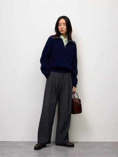 Model wearing the women's wide tuck pants shown full-length against a plain white background.