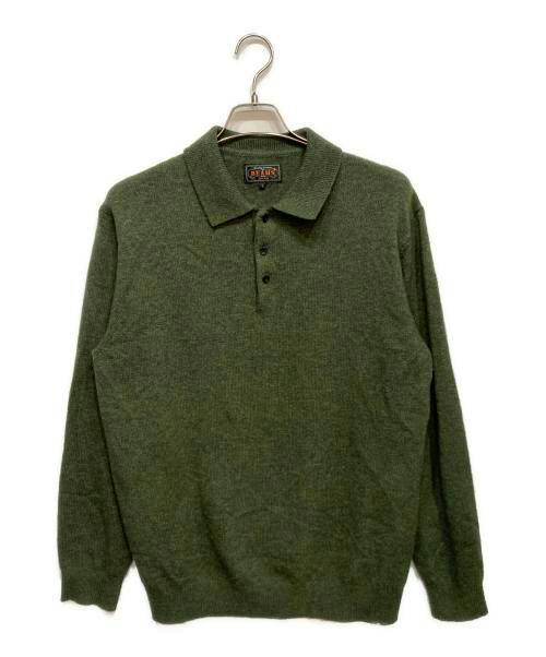 Green women's wool knit polo shirt displayed on a hanger against a white background.