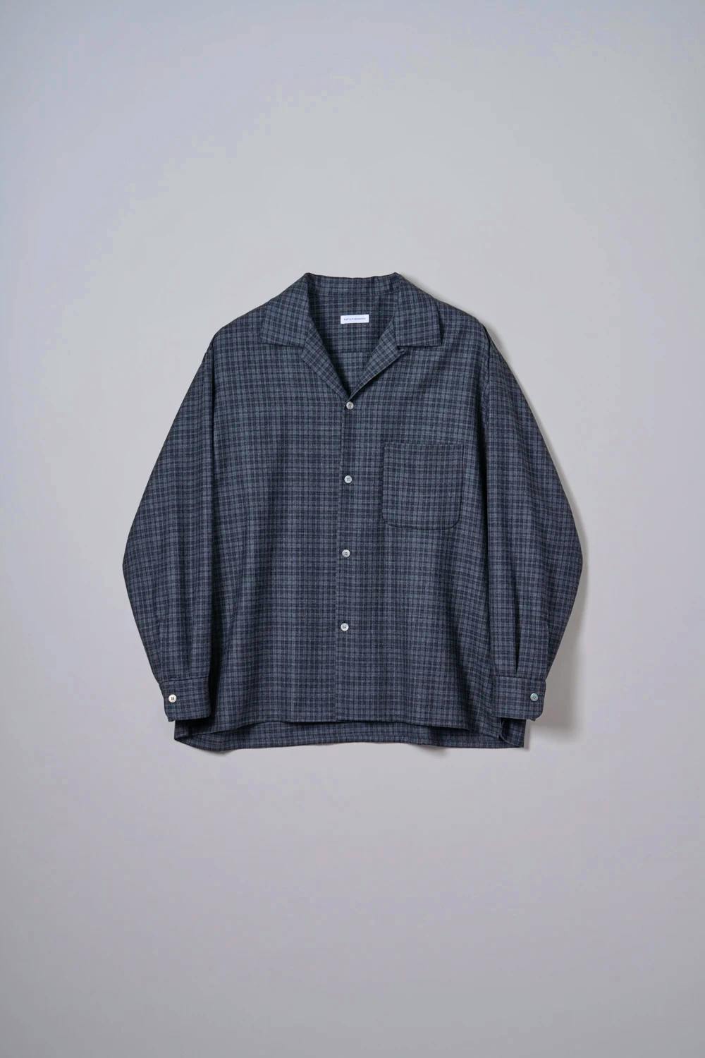 Front view of a women's wool plaid open-collar shirt laid flat against a light background.