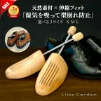 Pair of wooden shoe trees displayed beside shoes on a wooden surface.