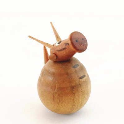 Wooden okiagari-koboshi (roly-poly) ornament shaped like a dragon with a rounded body and pointed head features.