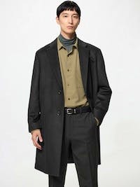 Male model wearing a black wool-cashmere chester coat.