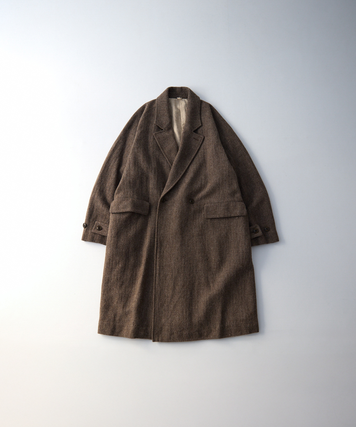 Brown wool-linen soft-tweed raglan men's coat laid flat on a light background.