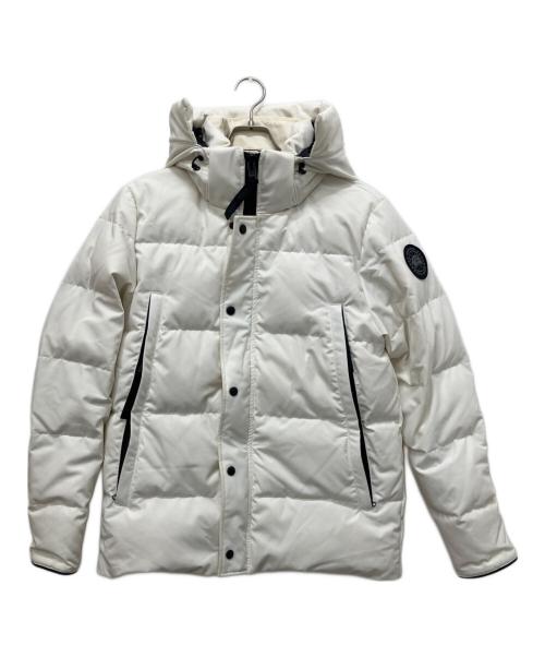 Front view of a white Wyndham Parka men's polyester puffer jacket with hood, center zipper and snap placket, two zip pockets, and a sleeve patch, shown on a hanger.