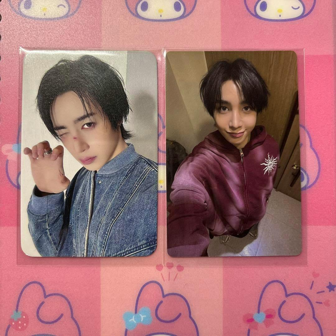 Two xikers ハンター photocard fronts displayed side-by-side in plastic sleeves showing portrait photos on a pink patterned background.