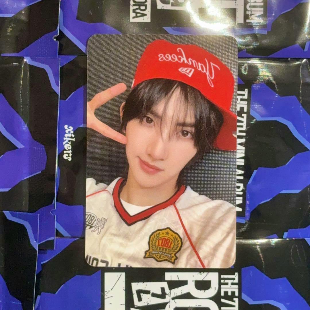 Front of the photocard showing a person wearing a red cap and white shirt making a peace sign.