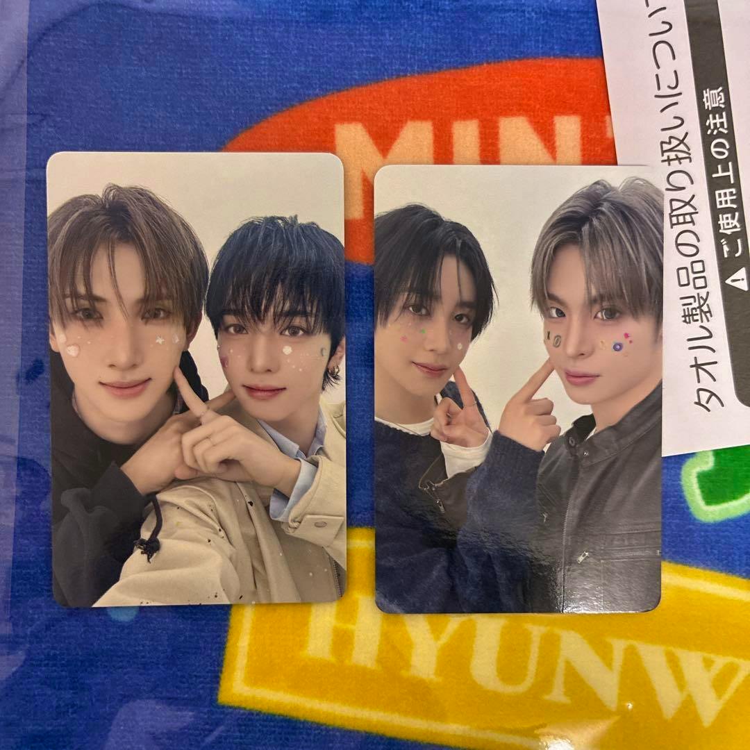 Two xikers unit photocard trading cards each showing two members, laid on a colorful fabric background.