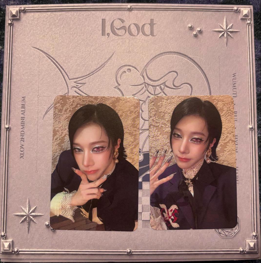Photograph of the XLOV I,God CD cover with two rectangular photocard images placed on top.