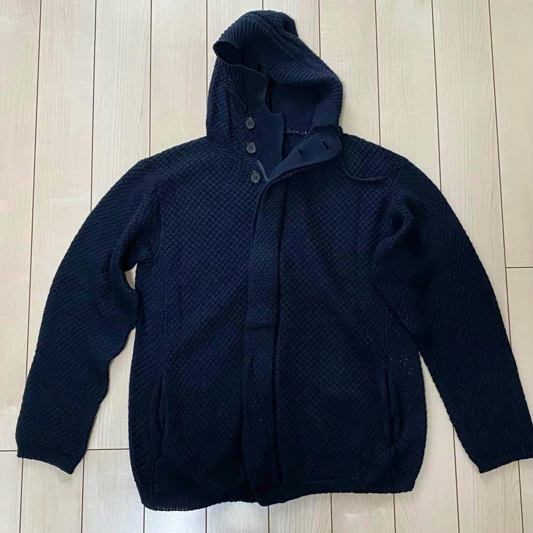 A Y's for men silk-cotton knit parka (hooded sweater) in dark navy laid flat on a light wood floor showing the front, hood, and sleeves.