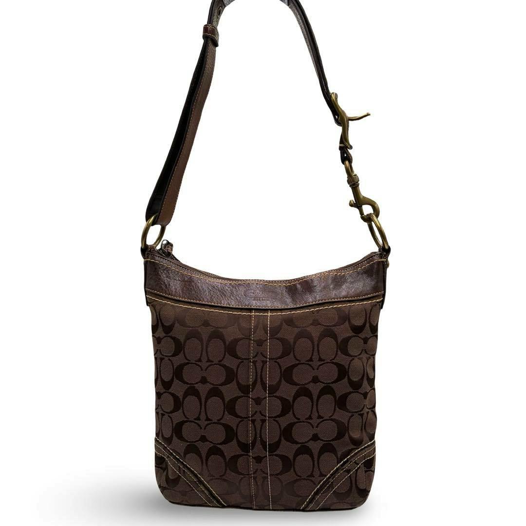 Front view of a brown Coach signature canvas shoulder bag with leather trim and an adjustable strap.