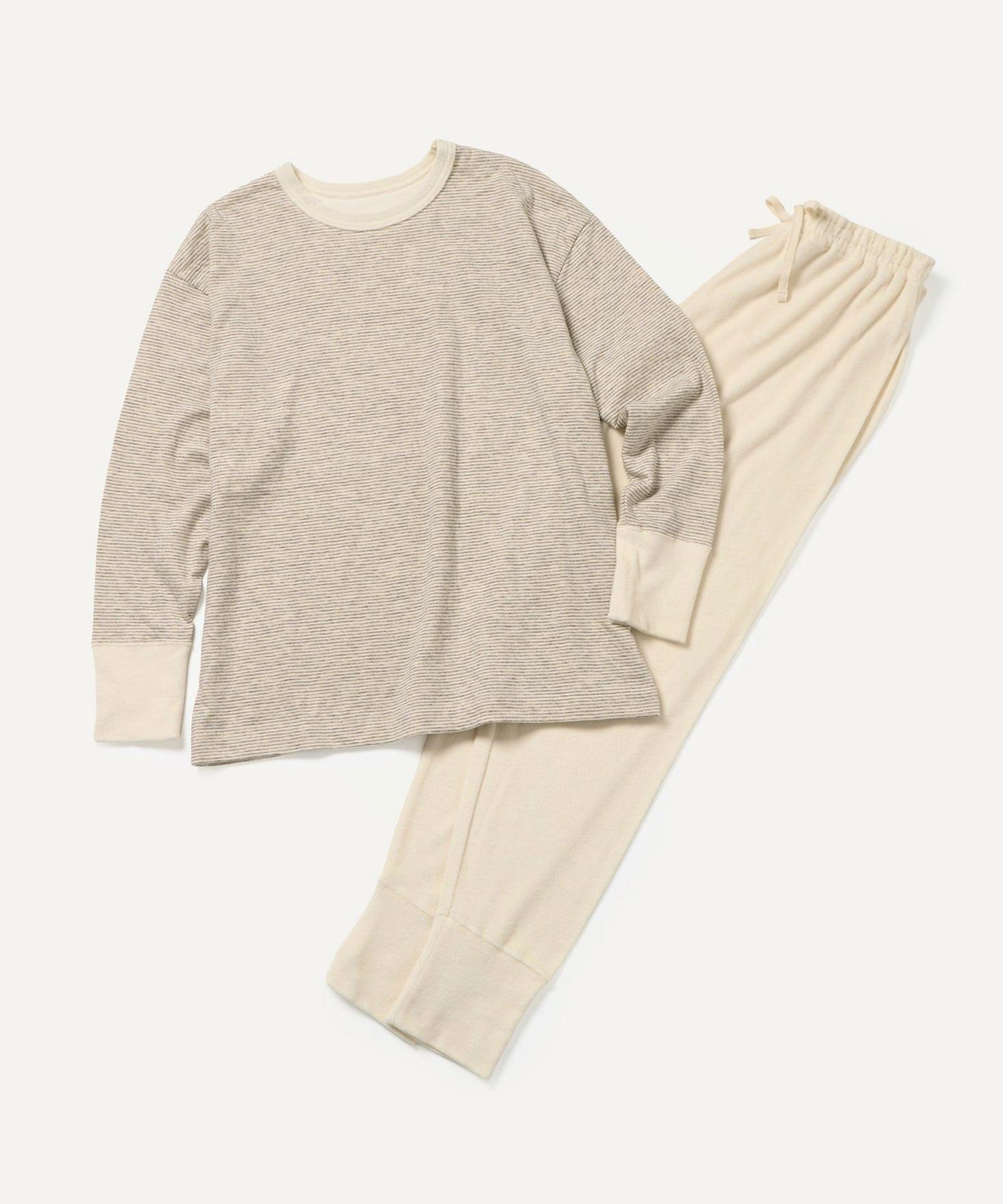 Flatlay of a women’s striped long-sleeve pajama top paired with solid light beige pajama pants.