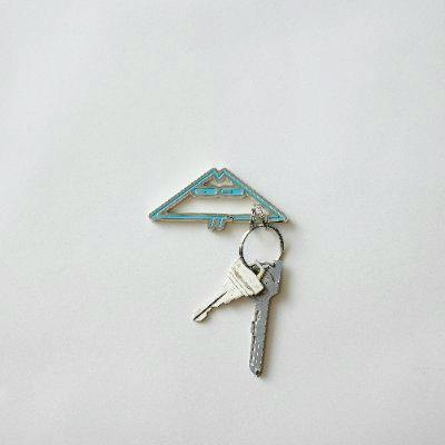 A yama character carabiner (zinc) in a triangular design attached to two keys on a white background.