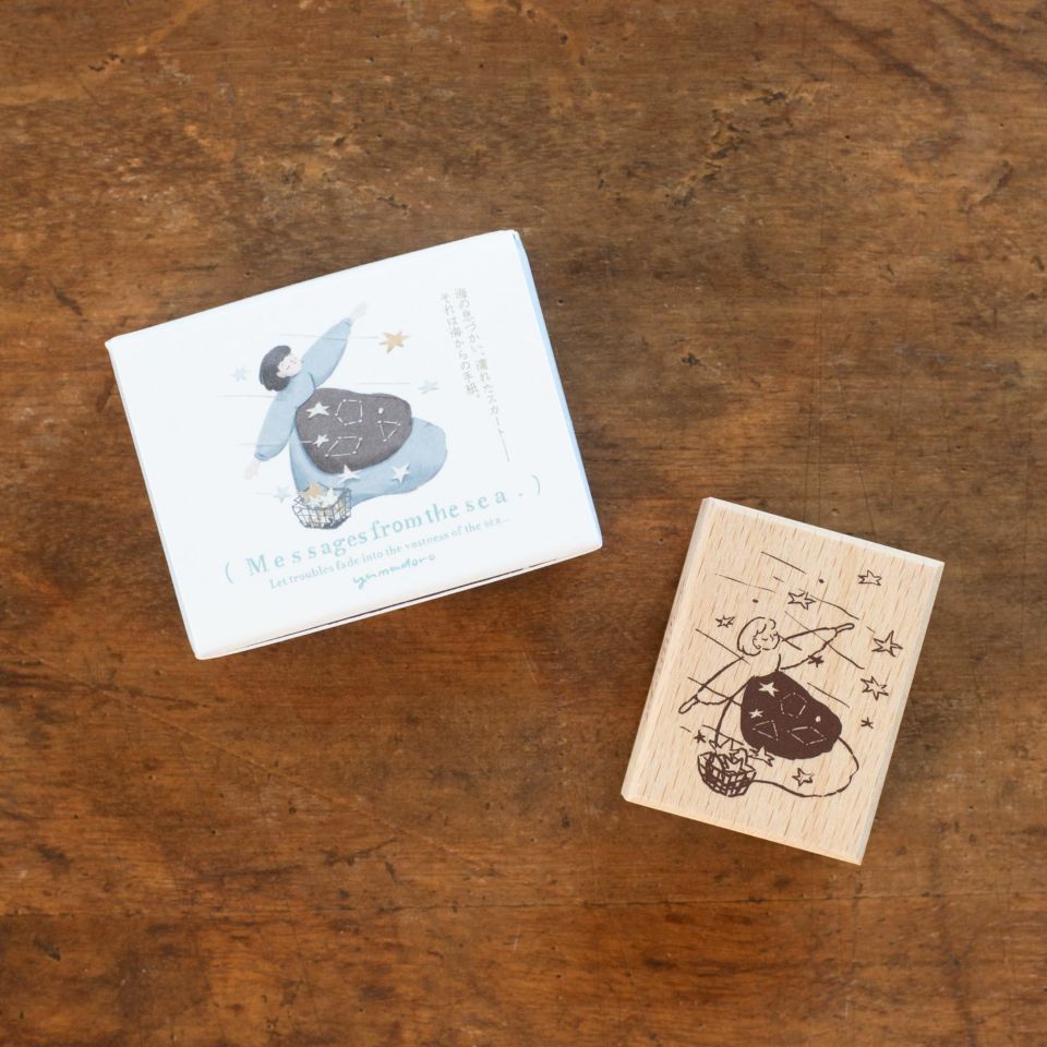 Wooden 'Messages from the sea - Myself' stamp and its illustrated box shown on a wooden surface.
