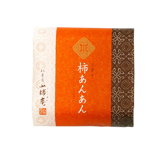Square package of the 山柿庵 柿あんあん fruit jelly in orange and brown decorative wrapping with Japanese text.