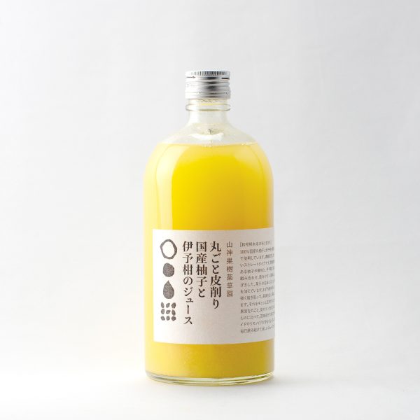 A glass bottle of yuzu and iyokan juice with a white label showing Japanese text.