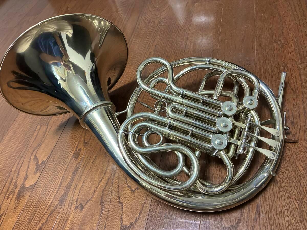 A Yamaha YHR-862 horn laid on a wooden floor showing its bell, coiled tubing, and rotary valve cluster.