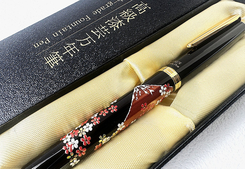 A Maki-e Urushi lacquer fountain pen with a Mt. Fuji cherry design shown in its black presentation case.