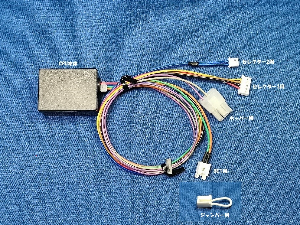 Black control CPU module with multicolored wiring harness and multiple white connectors for an arcade machine PCB board on a blue background.