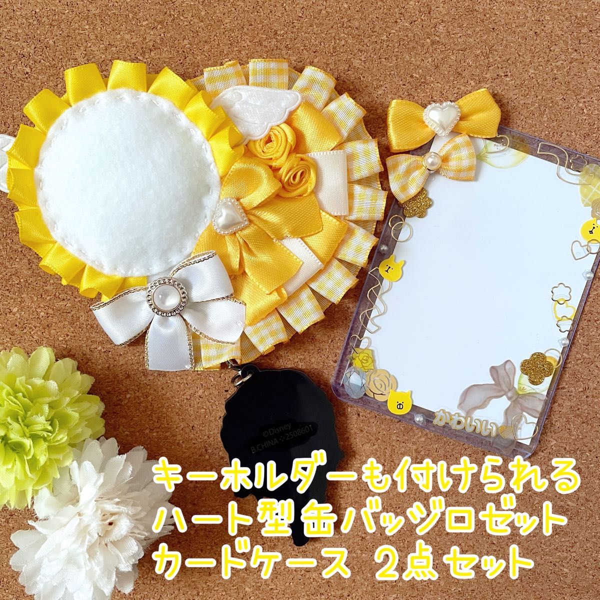 Yellow ribbon rosette and a clear decorative card case with a yellow bow displayed on a cork background.