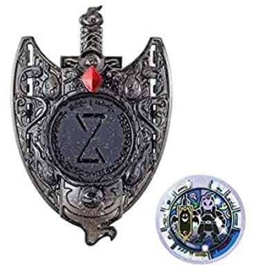 Toy Yo-kai Watch shield-shaped emblem with a red gem alongside a round Kaseki (fossil) medal from the set.