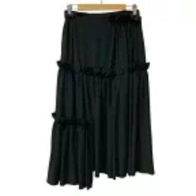 Black frill tiered women's long skirt (polyester) hanging on a wooden hanger.