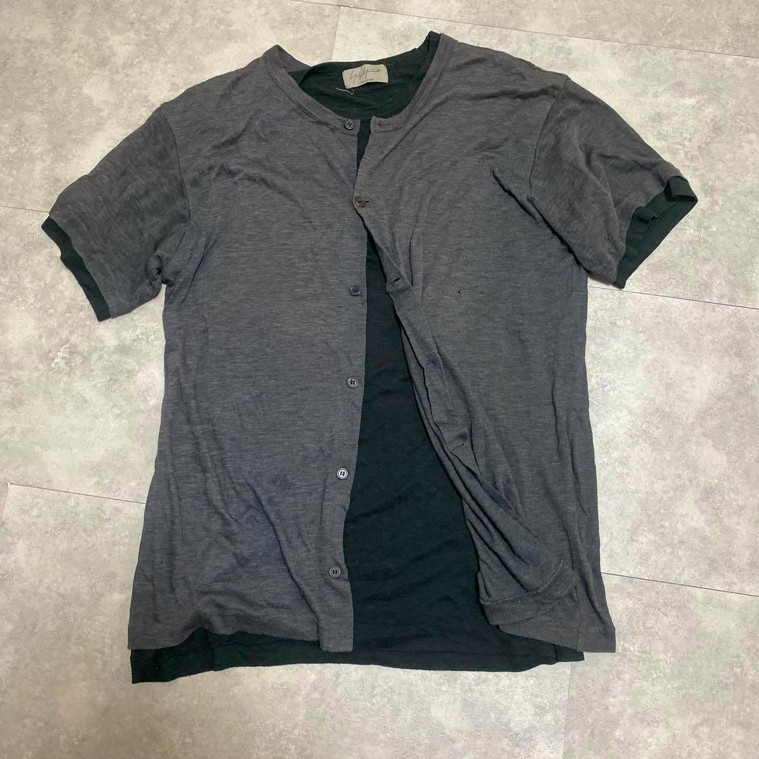 Gray layered Yohji Yamamoto Pour Homme short-sleeve T-shirt laid flat showing front buttons and inner black layer.