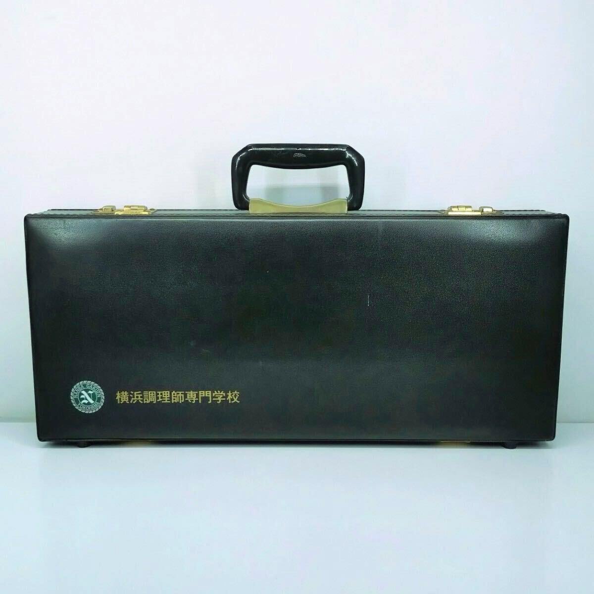 Closed black knife case with handle and gold “横浜調理師専門学校” text.