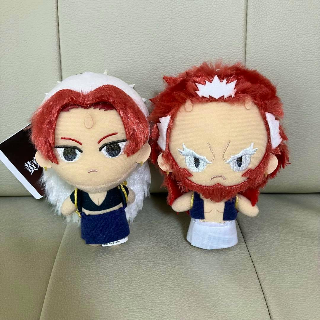 Two plush dolls from the listed product are shown side by side on a beige surface.
