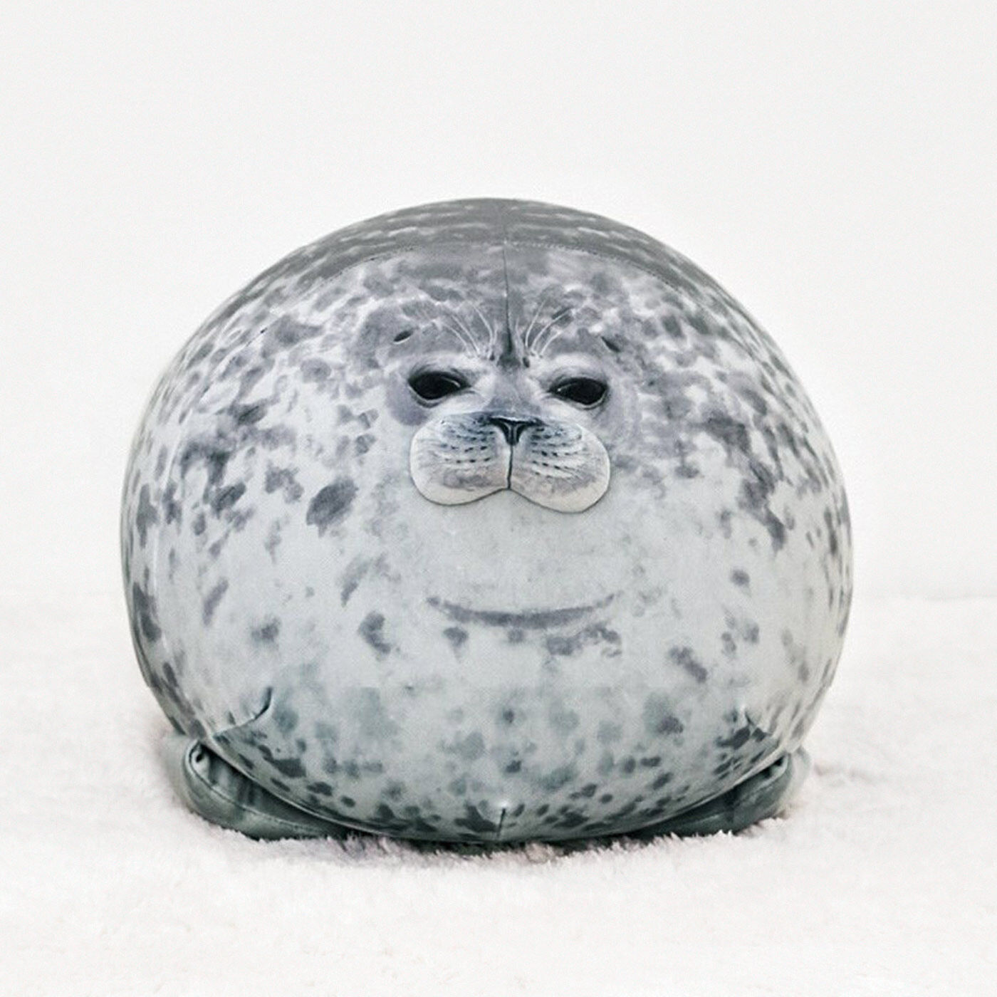 A round gray spotted seal-shaped cushion with a printed seal face on a white background.