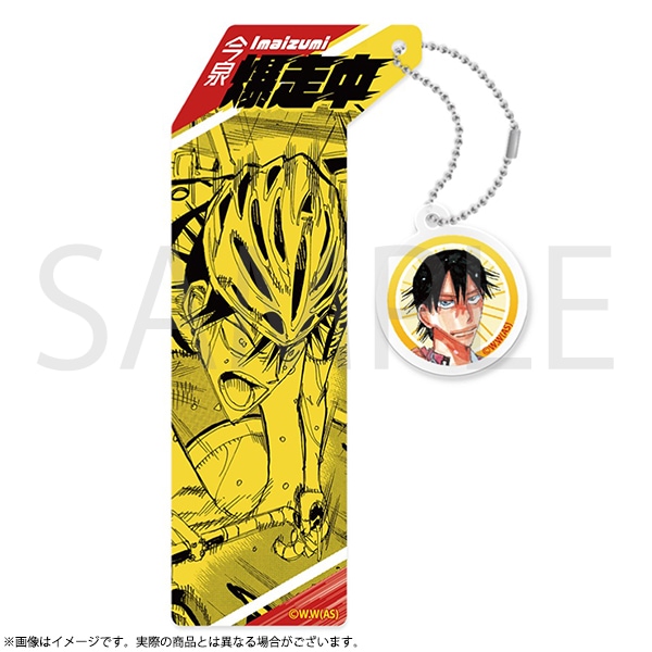 Yellow bookmark showing a manga-style cyclist illustration and a round dangling charm with Imaizumi Shunsuke's face on a white background.