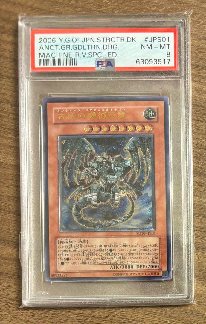 PSA-graded slab containing the Japanese Yu-Gi-Oh! trading card 古代の機械巨竜 with a visible PSA label showing grade 8.