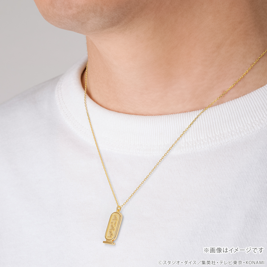 Close-up of a person's neck wearing the Atem cartouche silver necklace on a chain.