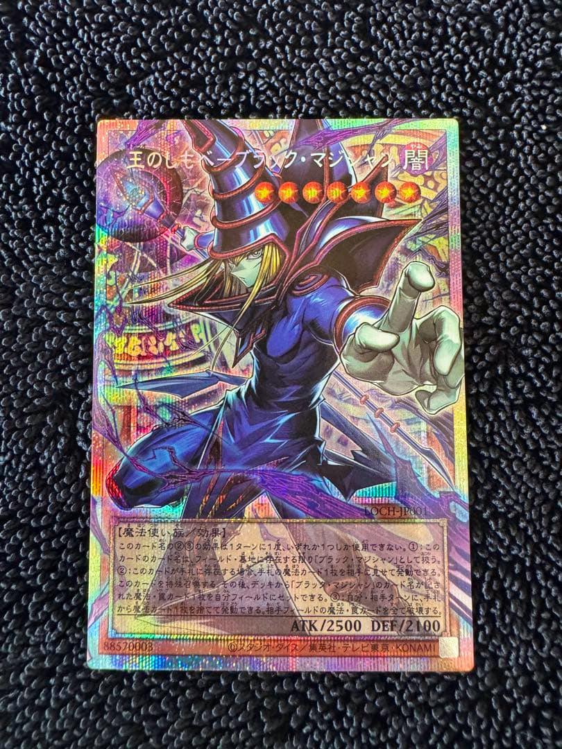 Front of the Japanese Yu-Gi-Oh! trading card 「王のしもべブラック・マジシャン」 with a holographic overframe/prism effect on a black textured background.