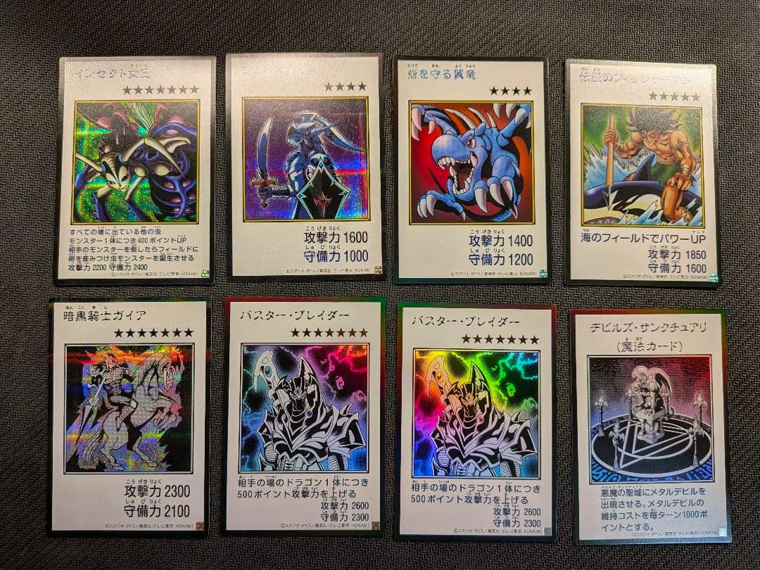 Eight manga-style Yu-Gi-Oh trading cards with holographic artwork laid out in two rows on a dark textured surface.