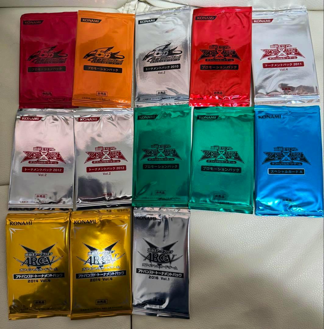 Sealed Konami Yu‑Gi‑Oh! OCG promotion and tournament pack foil booster packets in various colors arranged on a light surface.