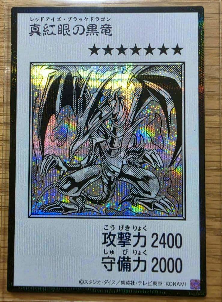 Front of the Japanese Red‑Eyes Black Dragon trading card in manga style with holographic foil and visible attack/defense stats.