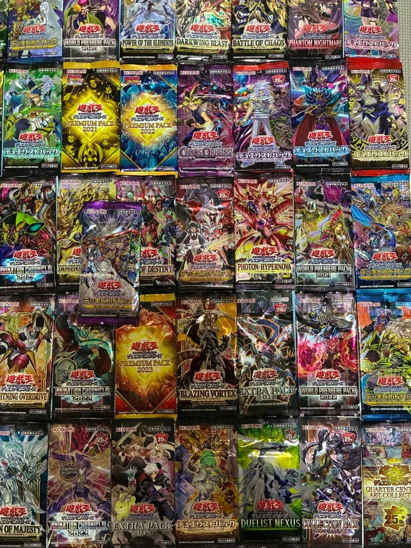 Photo showing many sealed Yu-Gi-Oh booster packs arranged in a grid pattern.