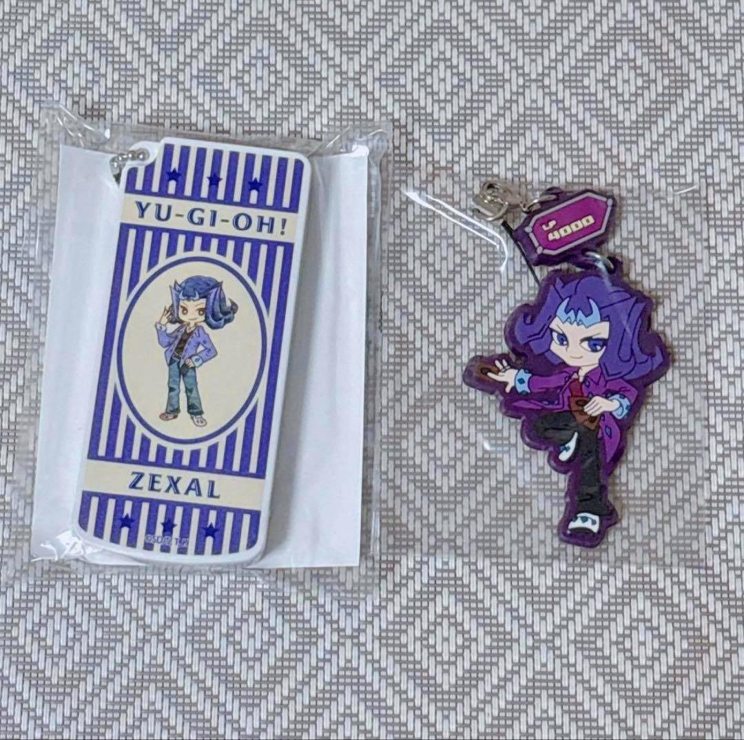 A Yu-Gi-Oh ZEXAL rubber character keychain (凌牙) and a slide-style small accessory case shown on a patterned surface.