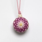 Fabric ornament (temari strap) showing a round embroidered purple-pink floral ball hanging from a pink cord.