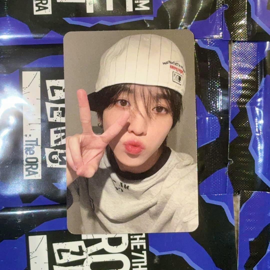 Front of the photocard showing a person wearing a white cap making a peace sign while puckering their lips.