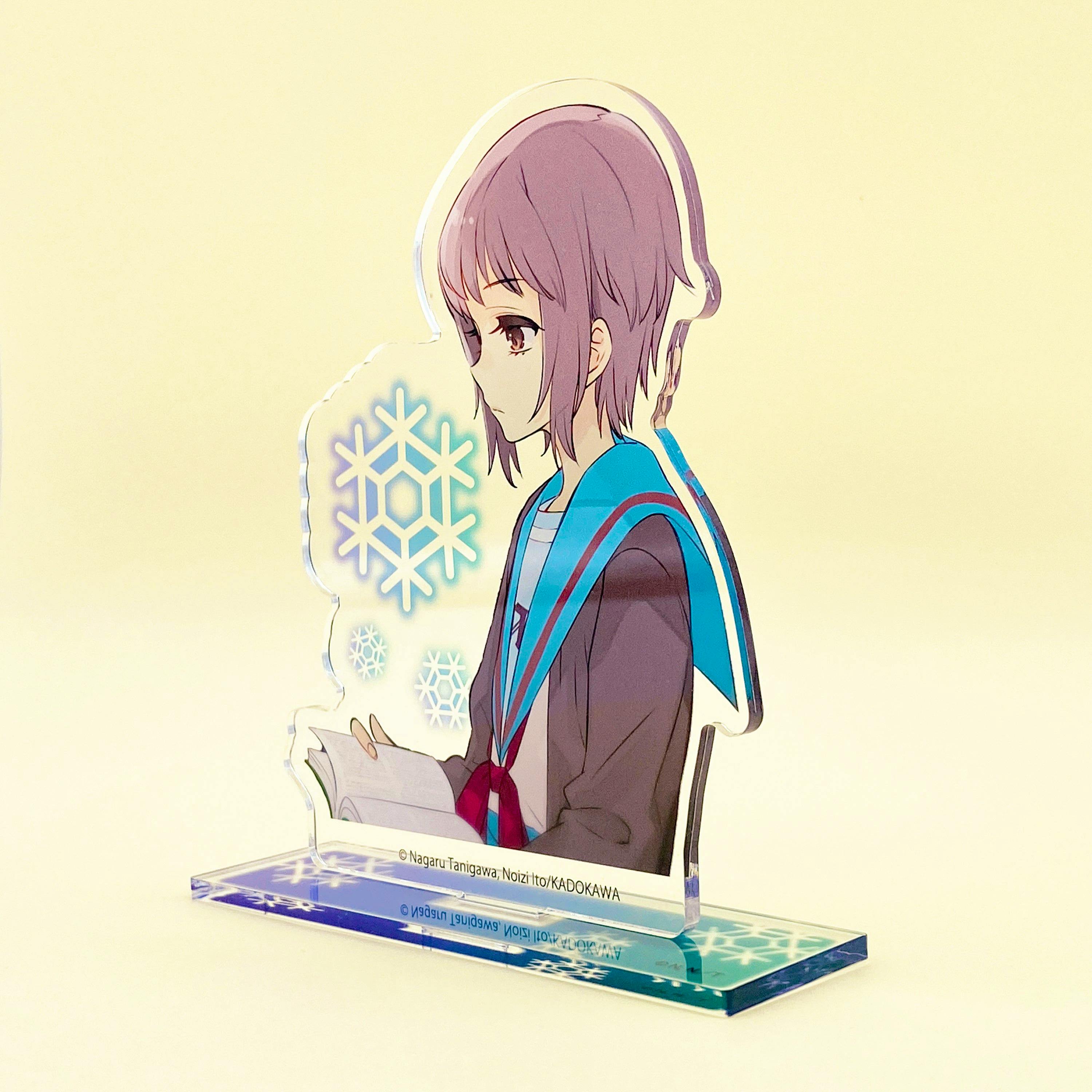 Front view photo of the acrylic stand (Nagato Yuki reading) showing the printed character panel and the clear base with snowflake design.
