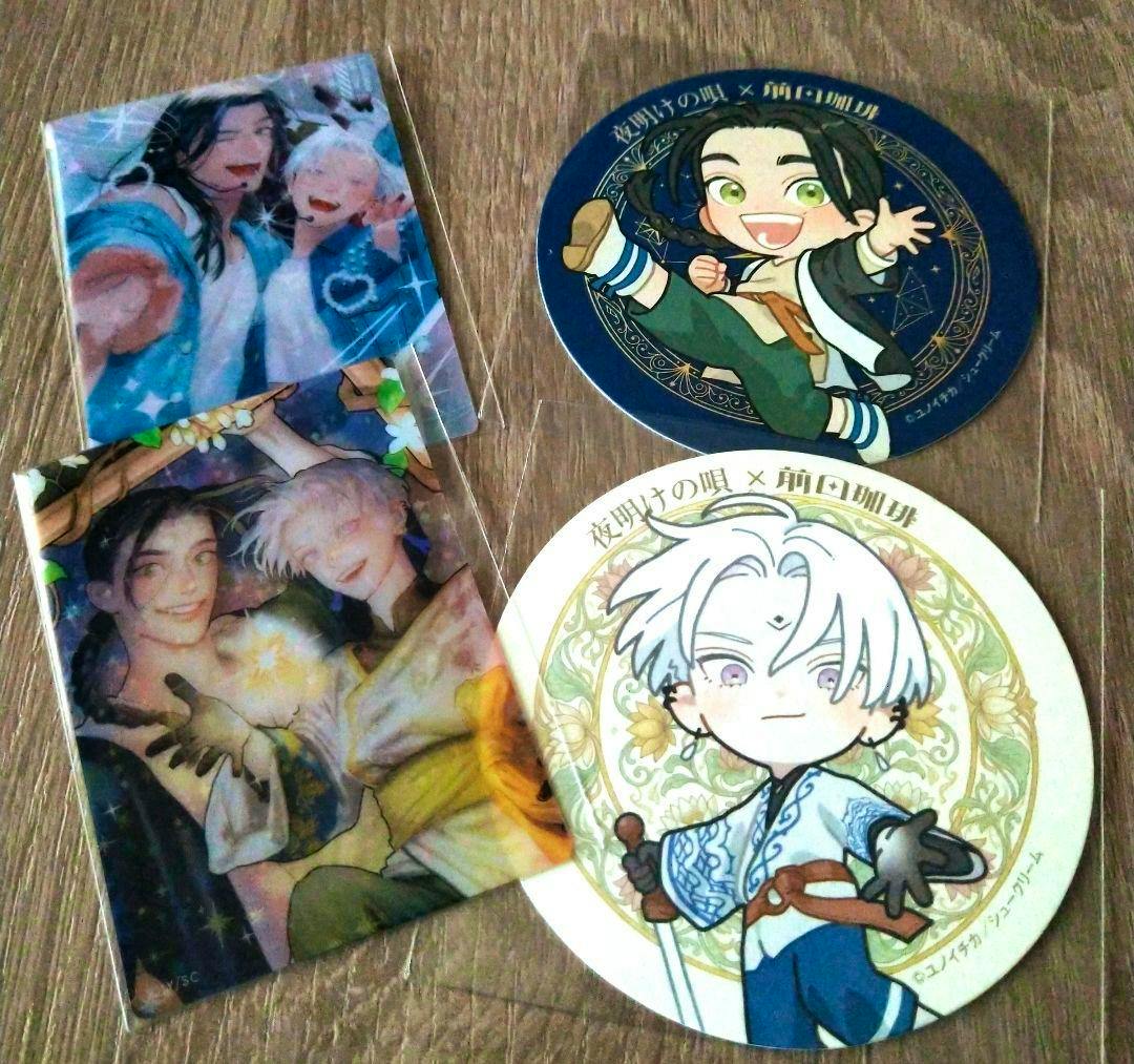 Two rectangular illustrated clear cards and two round character coasters from the random clear card and coaster set shown on a wooden surface.