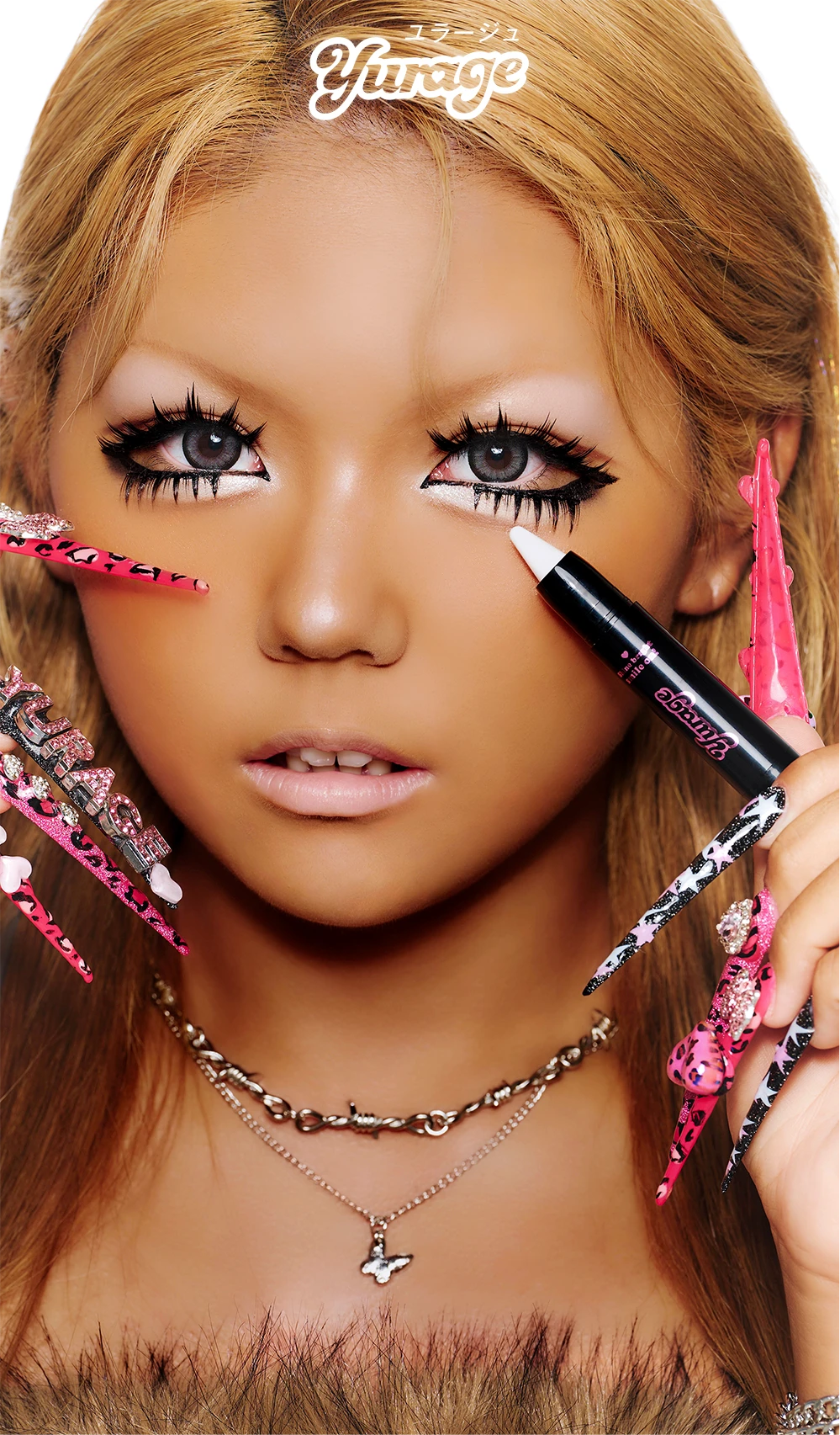Close-up of a model holding a white eye shadow pencil near her eye.